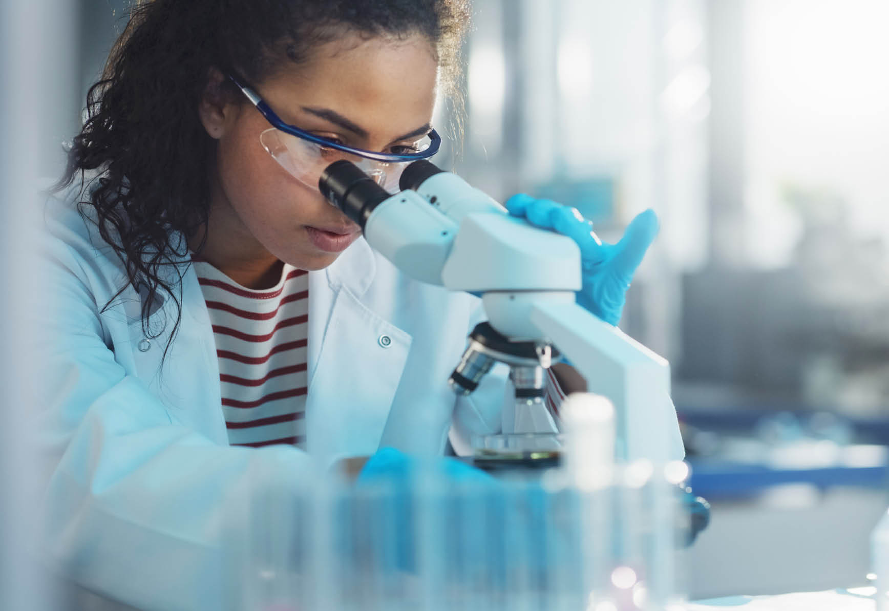 Medical Science Laboratory: Portrait of Beautiful Black Scientist Looking Under Microscope Does Analysis of Test Sample. Ambitious Young Biotechnology Specialist, working with Advanced Equipment